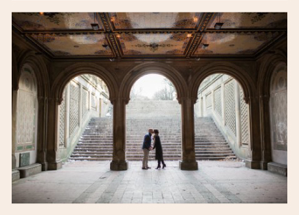 Ashley kissing her husband under a bridge.