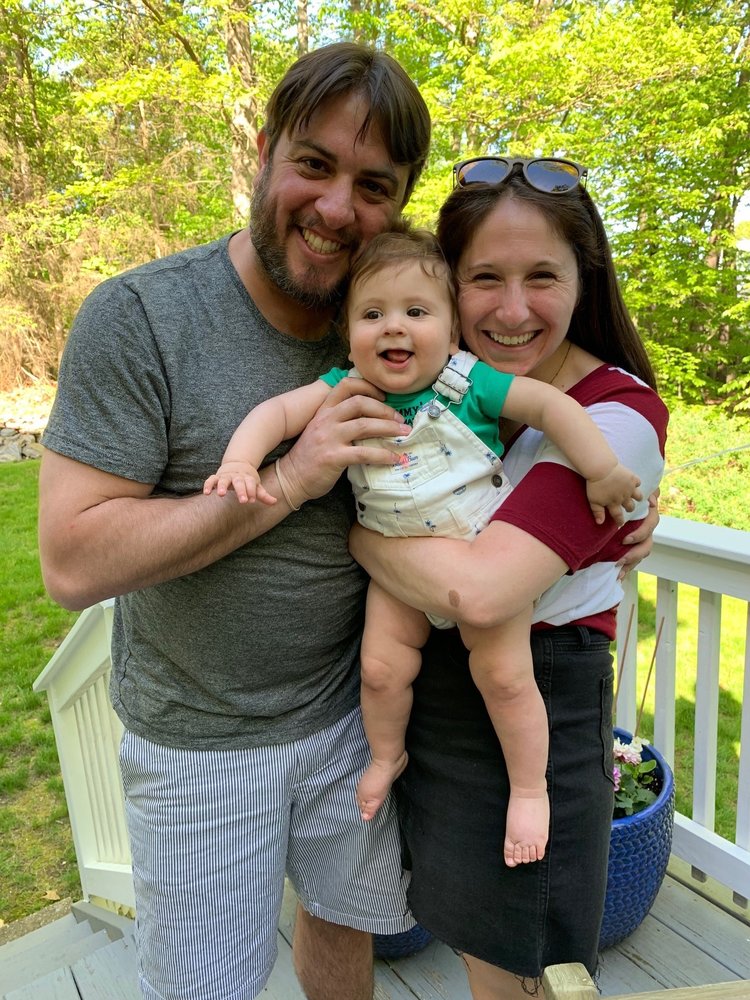 Picture shows a man and a woman holding an infant